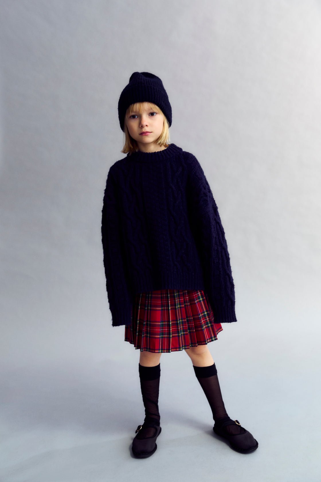 Pleated skirt with an inner pant lining, featuring a waistband with belt loops and a side zipper opening in a matching tone.