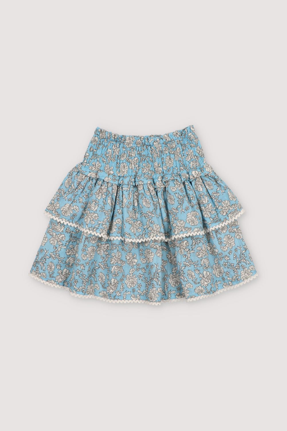 Melina Skirt in 100% cotton muslin with our peony powder blue print. Our iconic skirt with smocking to create volume and two ruffles.
