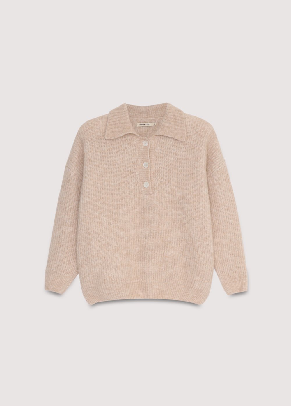 Polo en tricot de laine de qualité exquise, doté d'une ouverture sur le devant avec de beaux boutons ton sur ton.