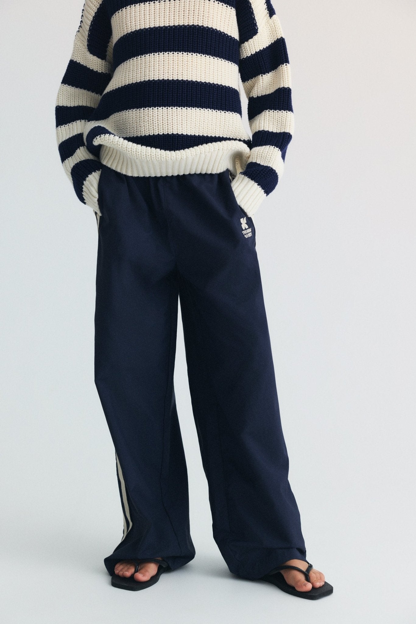 Notre pull classique à rayures bicolores en tricot de coton côtelé, avec des finitions côtelées à l'encolure, aux manches et à l'ourlet pour une coupe confortable et raffinée.