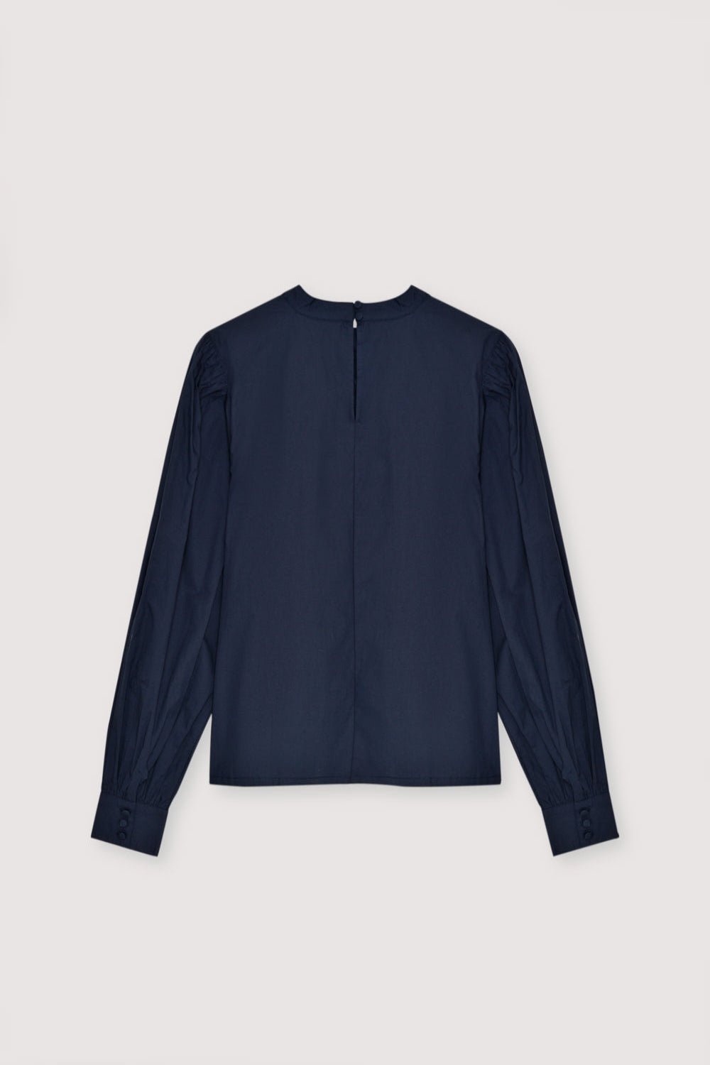 Blouse en popeline avec détail brodé et plis sur le devant. Il présente des poignets boutonnés et des manches froncées aux épaules. Le chemisier s'ouvre dans le dos par une goutte d'eau et un bouton.
