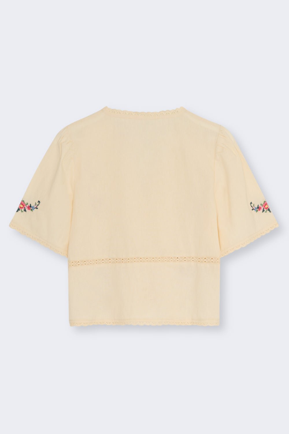 Confeccionada en suave 100 % algodón, esta blusa presenta un favorecedor escote en V y una abertura frontal con delicados cierres de lazo.