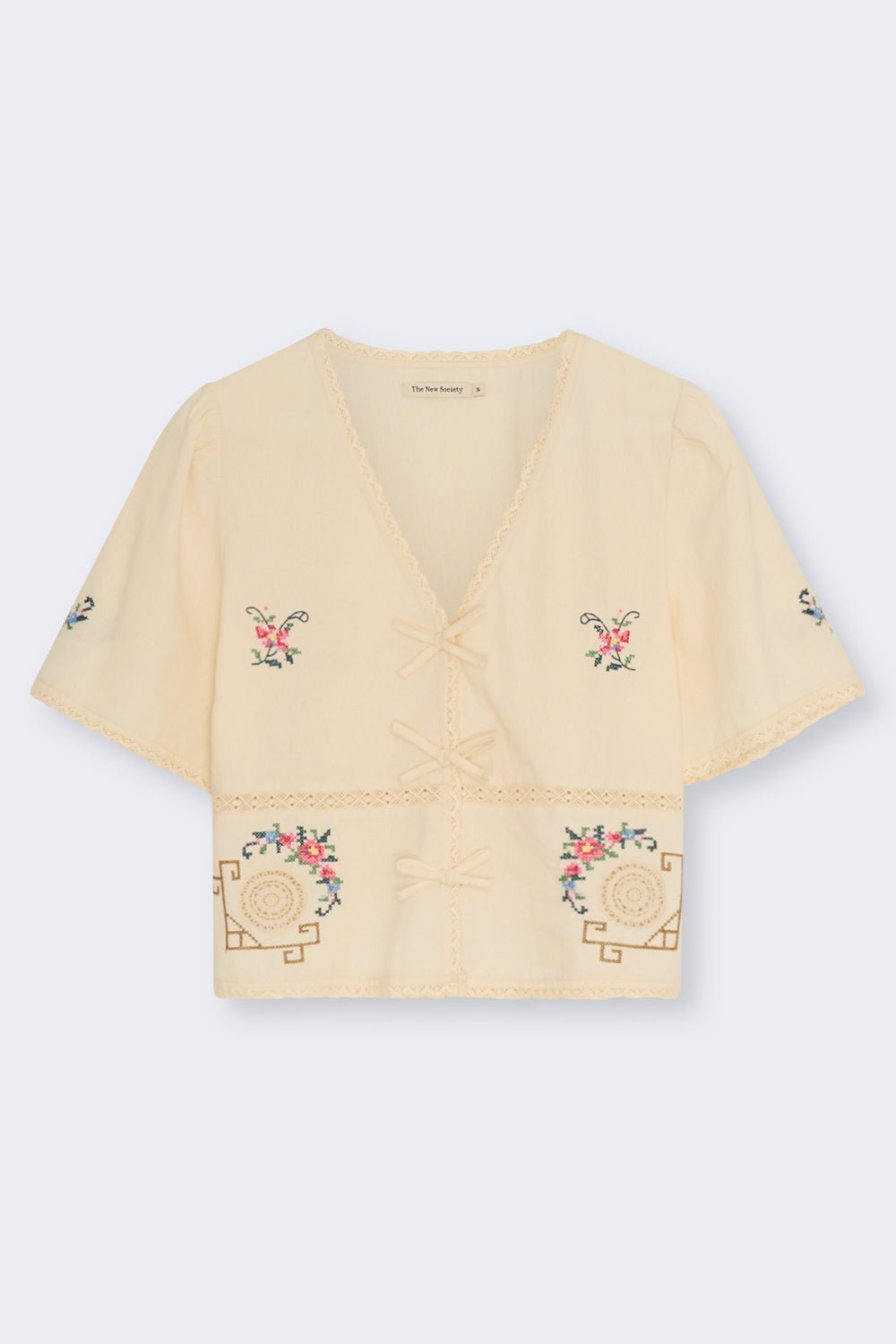 Confeccionada en suave 100 % algodón, esta blusa presenta un favorecedor escote en V y una abertura frontal con delicados cierres de lazo.