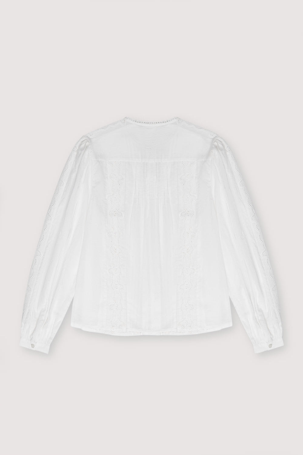 Romantic-style blouse with delicate embroidery details and puffed sleeves. It has a round neckline with lace detail and a tone-on-tone mother-of-pearl button opening.