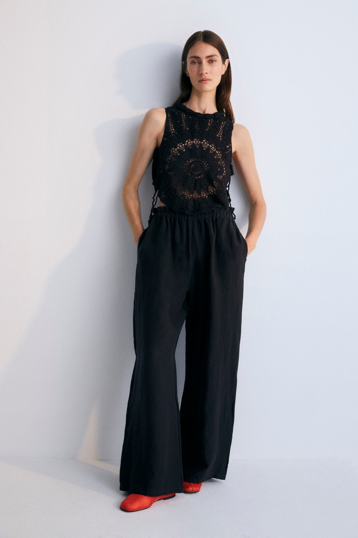 Crochet top with open back and closure with fabric ties at the back.