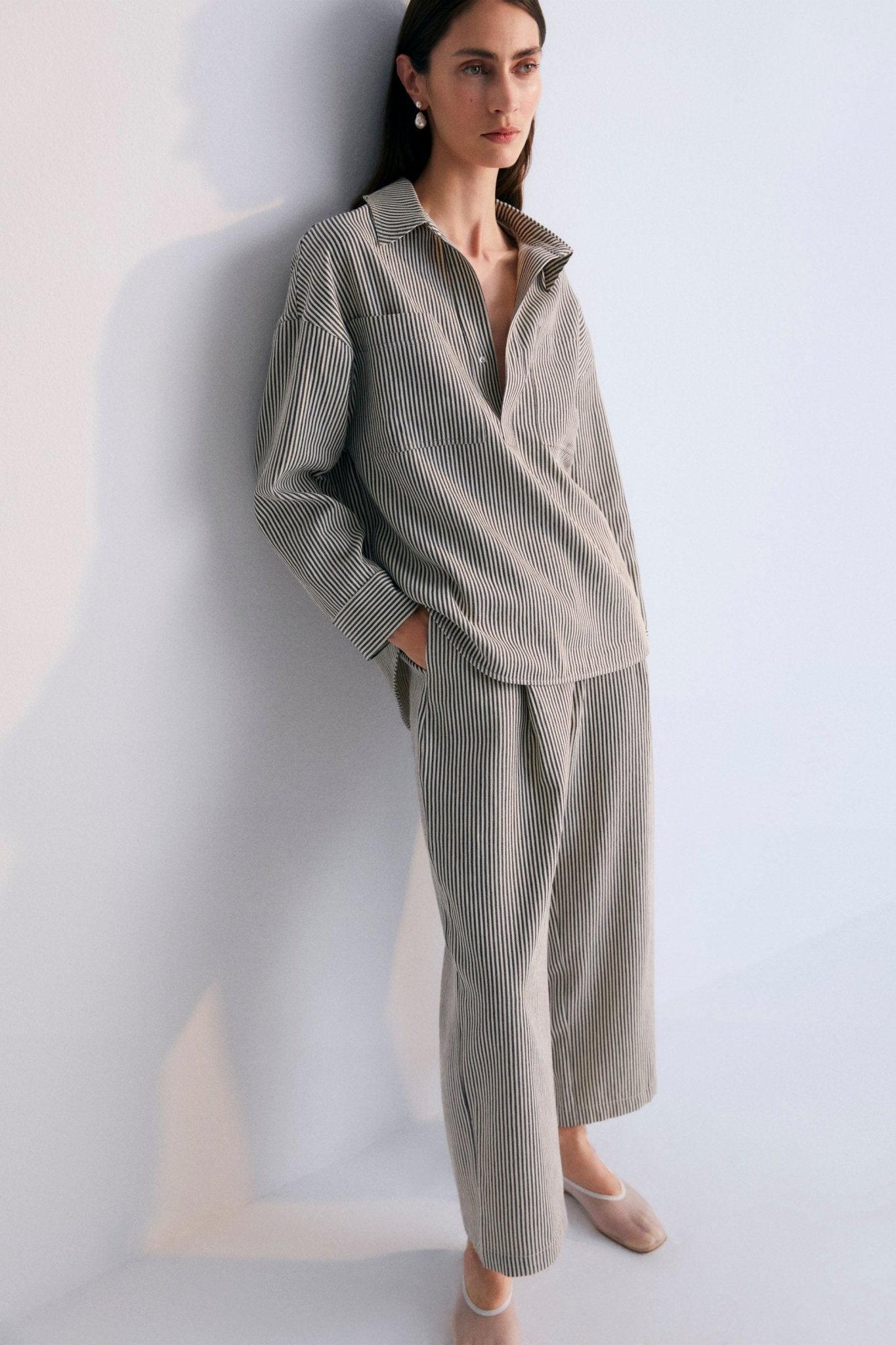 Polo-style striped shirt with patch pockets on the front. It has matching pants, perfect for a comfortable and versatile look.