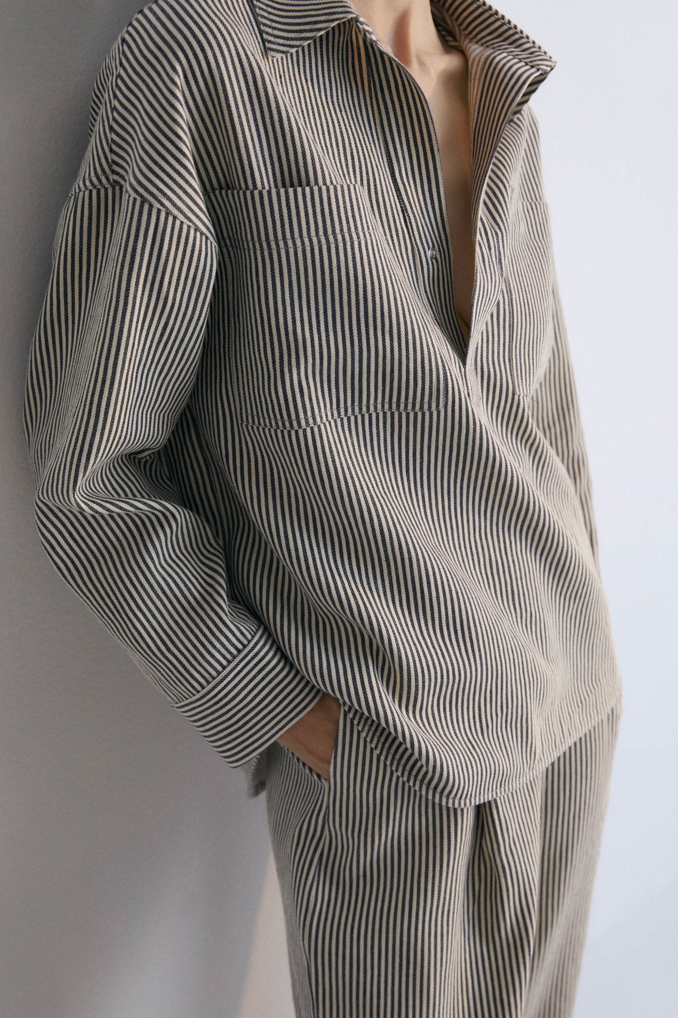 Polo-style striped shirt with patch pockets on the front. It has matching pants, perfect for a comfortable and versatile look.