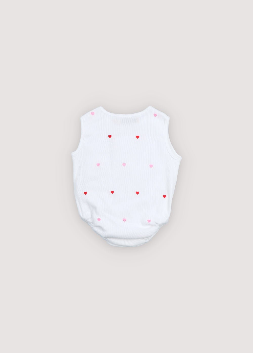 A soft cotton baby bodysuit featuring a delicate all-over heart print and a subtle logo detail on the front. 