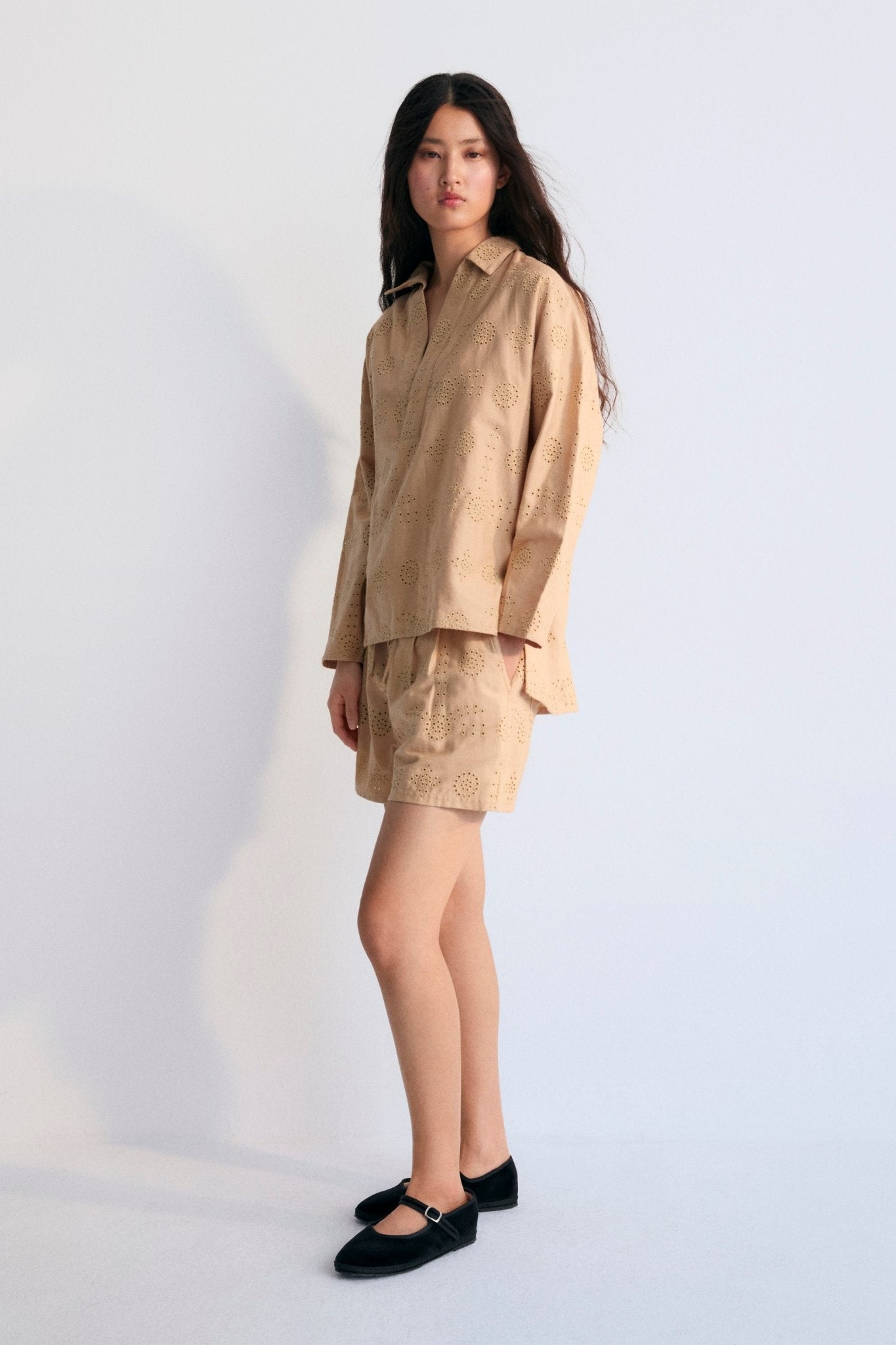 This polo-style shirt is adorned with delicate tone-on-tone embroidery, adding a subtle yet refined touch to the classic design. 