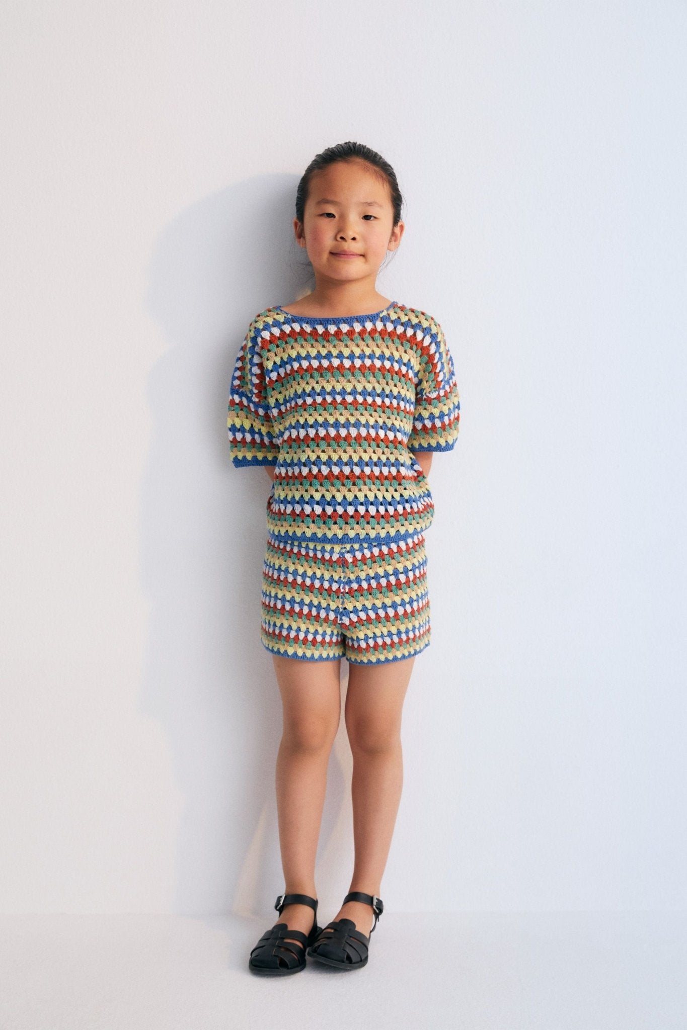 Crochet shorts with colorful stripes and ribbed elastic waistband. It comes with a jumper and a bucket hat to create a total look. Spring Summer Collection. The New Society. 