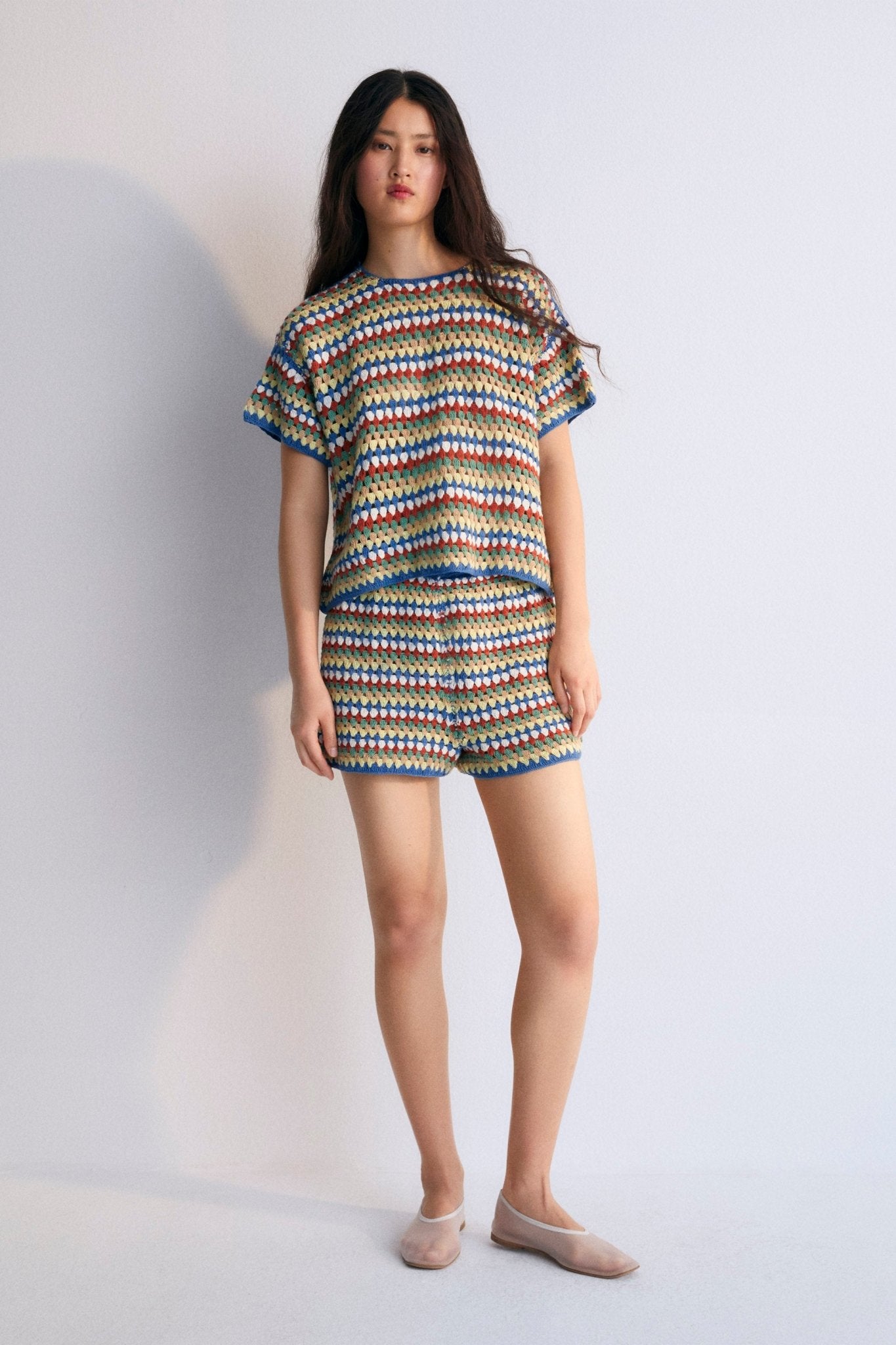 Short-sleeved crochet sweater with colorful stripes and ribbed hem. It comes with shorts and a bucket hat to create a total look.
