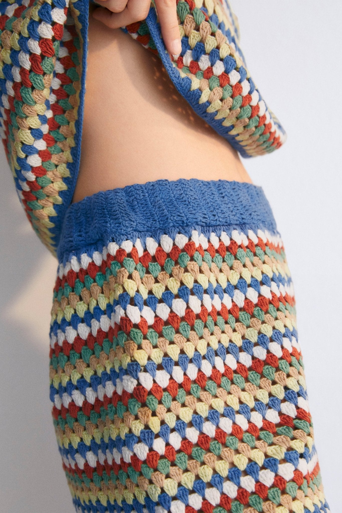 Short-sleeved crochet sweater with colorful stripes and ribbed hem. It comes with shorts and a bucket hat to create a total look.