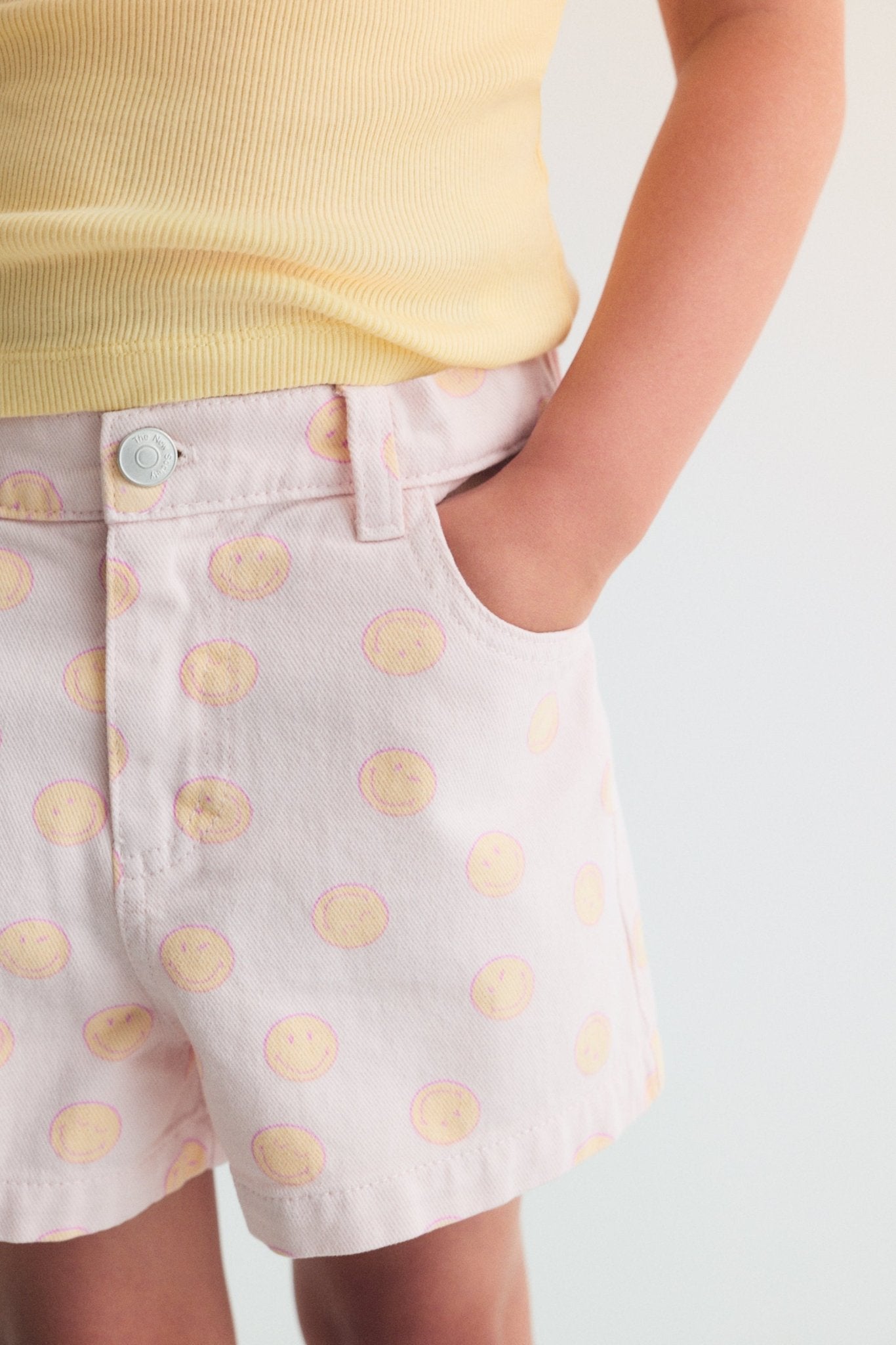 Pantalones cortos de mezclilla en algodón BCI con un divertido estampado SmileyWorld®, una cinturilla elástica ajustable con elástico interior y un parche en el bolsillo trasero para un ajuste divertido y cómodo.