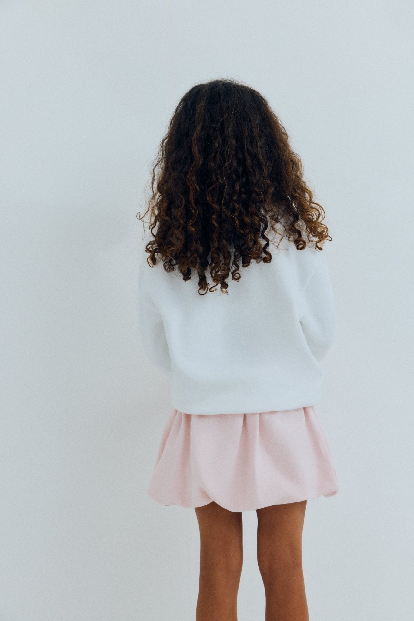 Bringen Sie Spaß und Komfort in die Garderobe Ihres Kindes mit diesem weißen Sweatshirt von „The New Society’ x SmileyWorld-Zusammenarbeit.