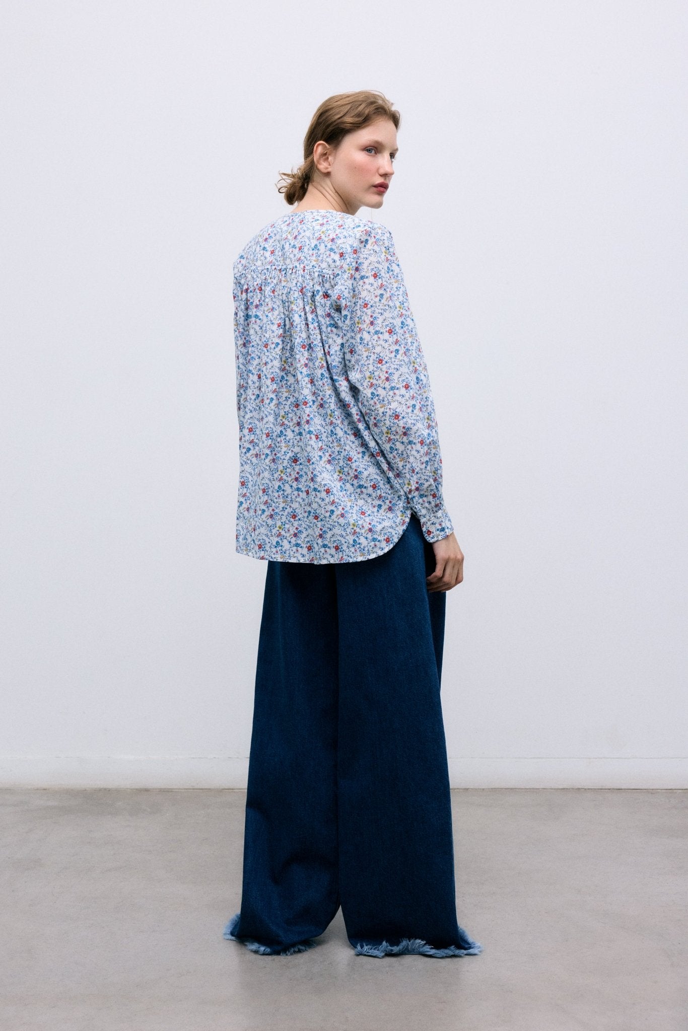 Dark wash denim pants with an extra-wide, relaxed fit. Designed with front and back pockets, side seam cuts that add volume to the leg, and a branded embroidery detail on the back waistband for a distinctive finish.